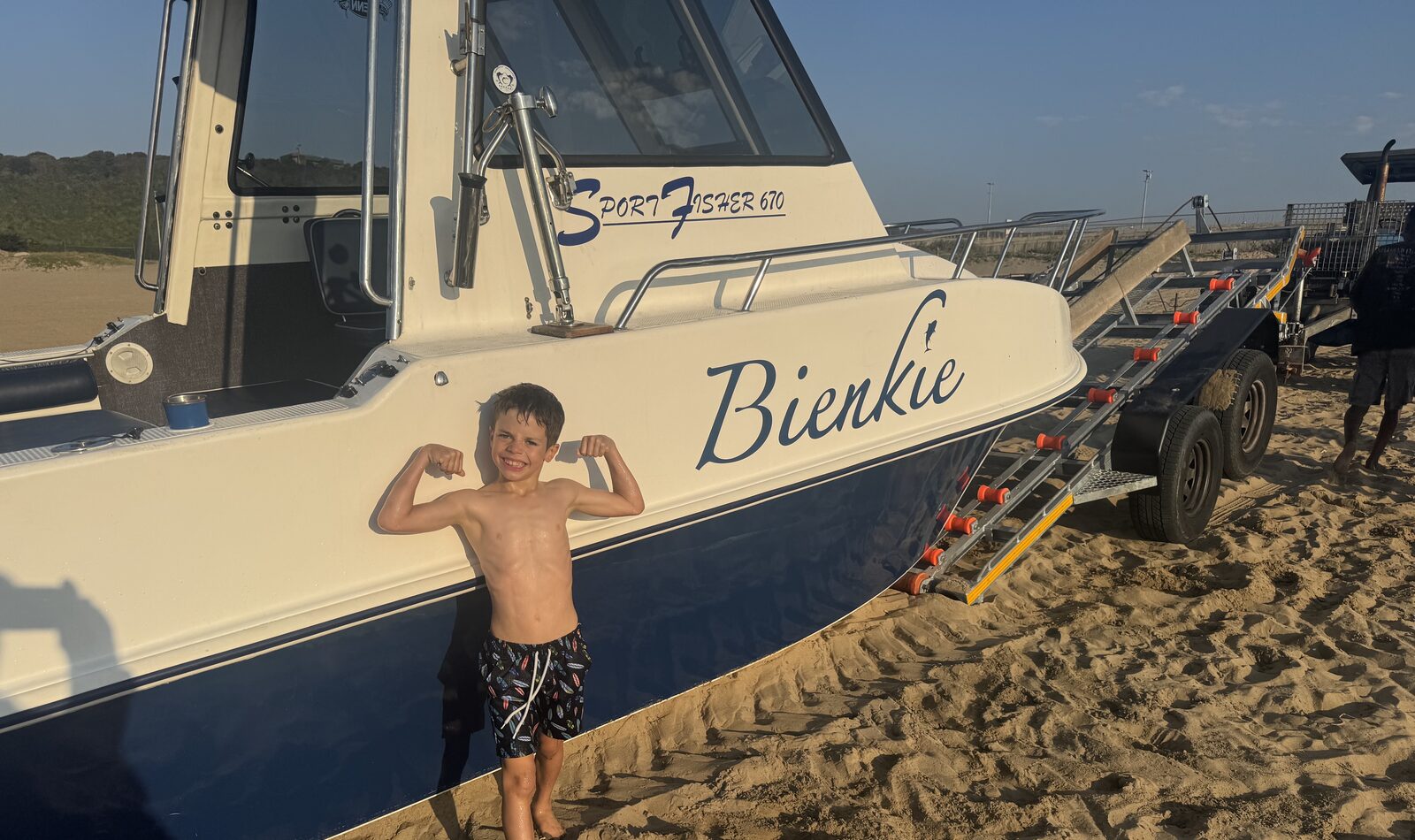 A young crew member on the beach in front of the Bienkie