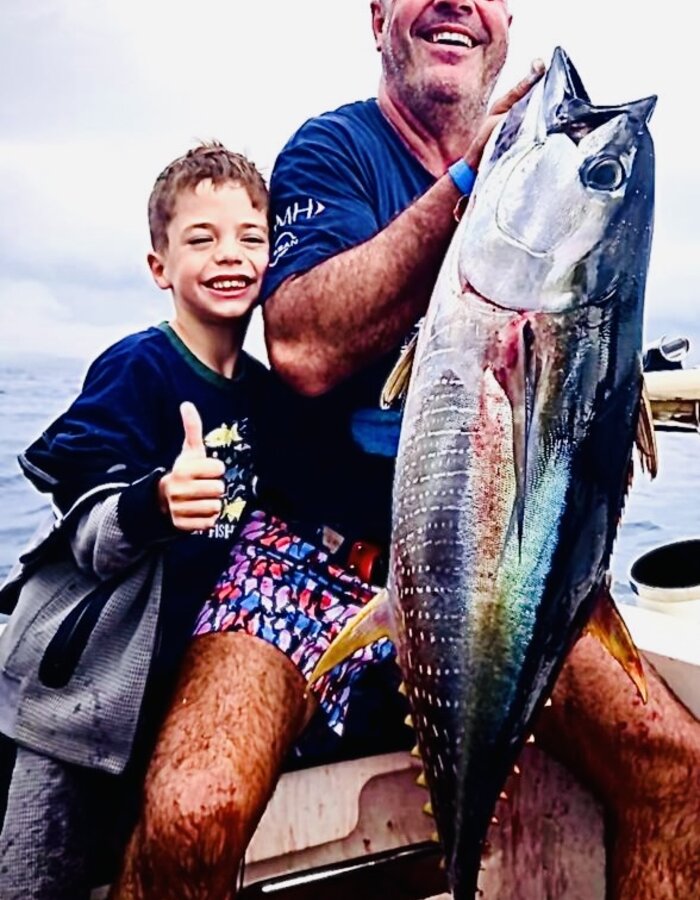 A young crew member with a tuna catch aboard the Bienkie